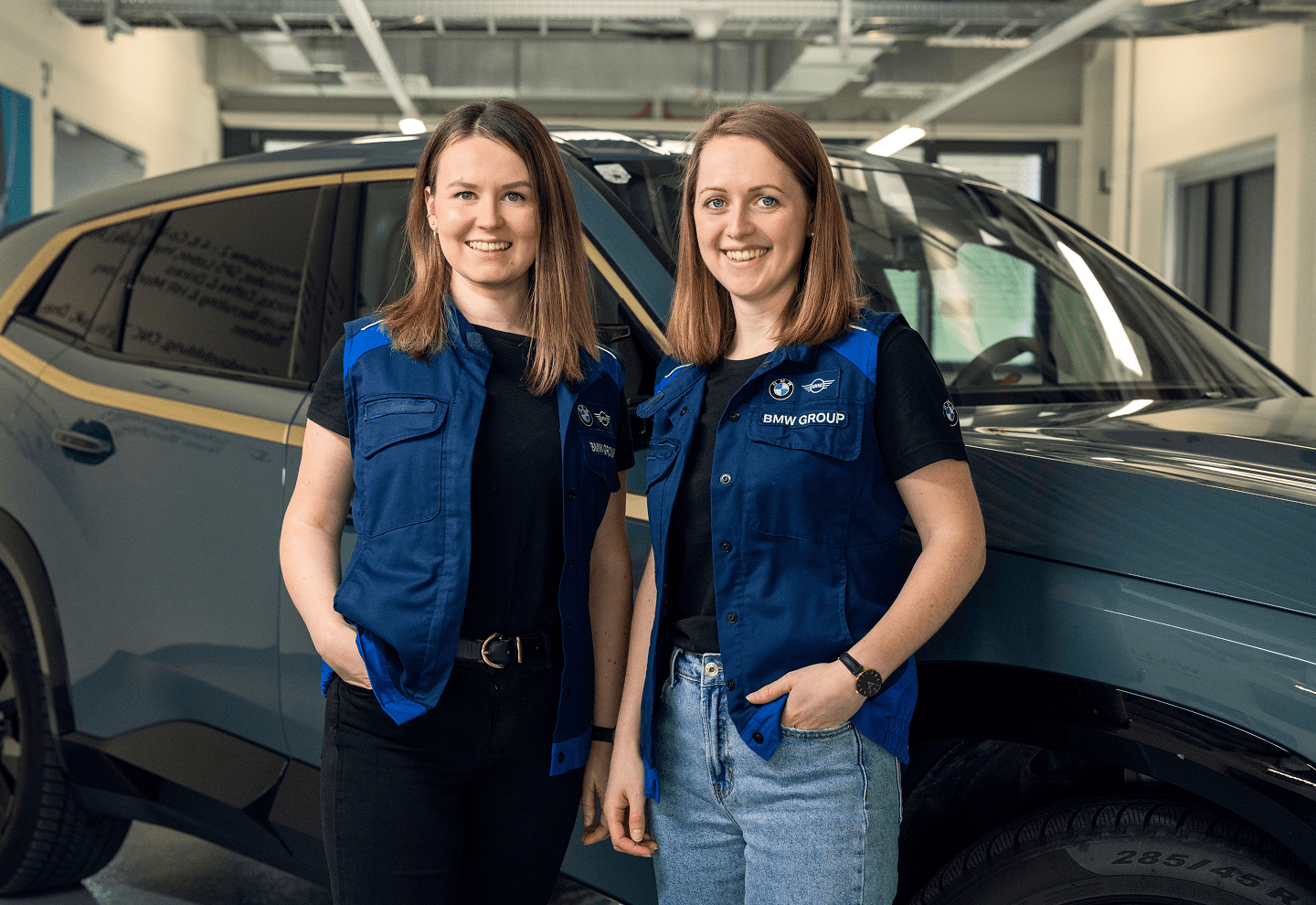 Two employees from BMW standing in front of a car